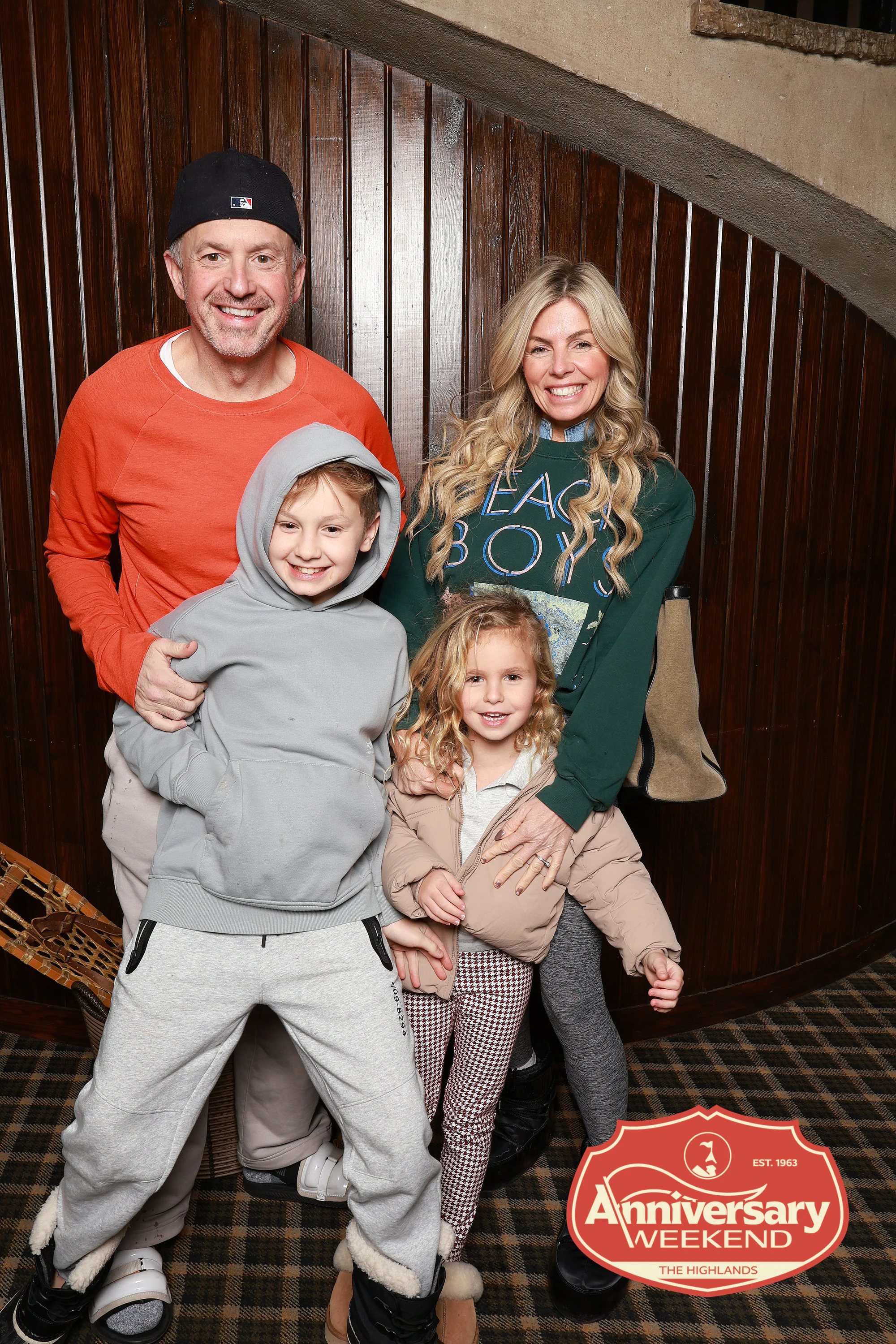 The family of four, the boy in the grey hoodie crouching to pose at The Highlands Anniversary Weekend