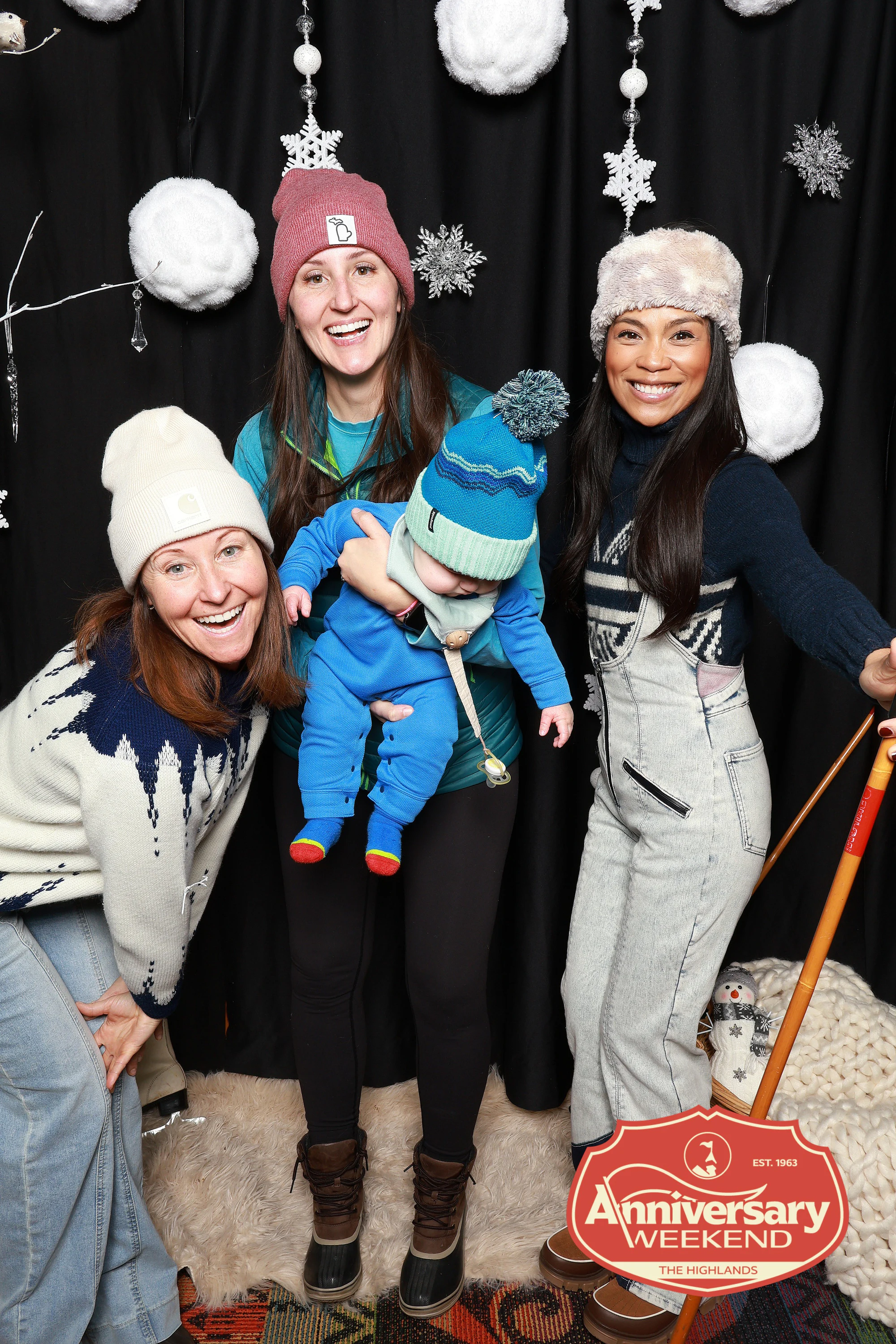 The three women and the baby, one leaning in laughing at The Highlands Anniversary Weekend