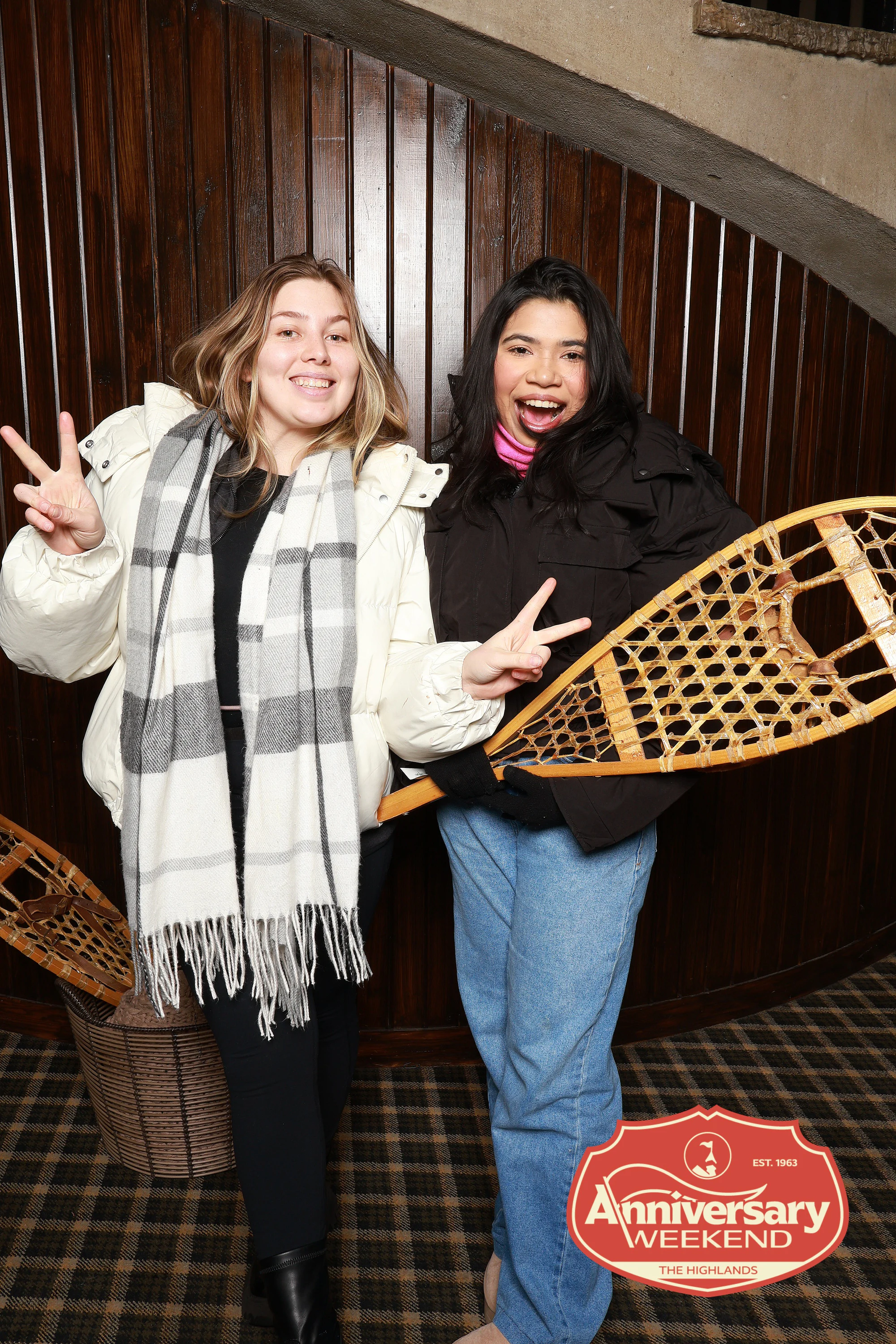 The two friends with peace signs and a wooden snowshoe at The Highlands Anniversary Weekend