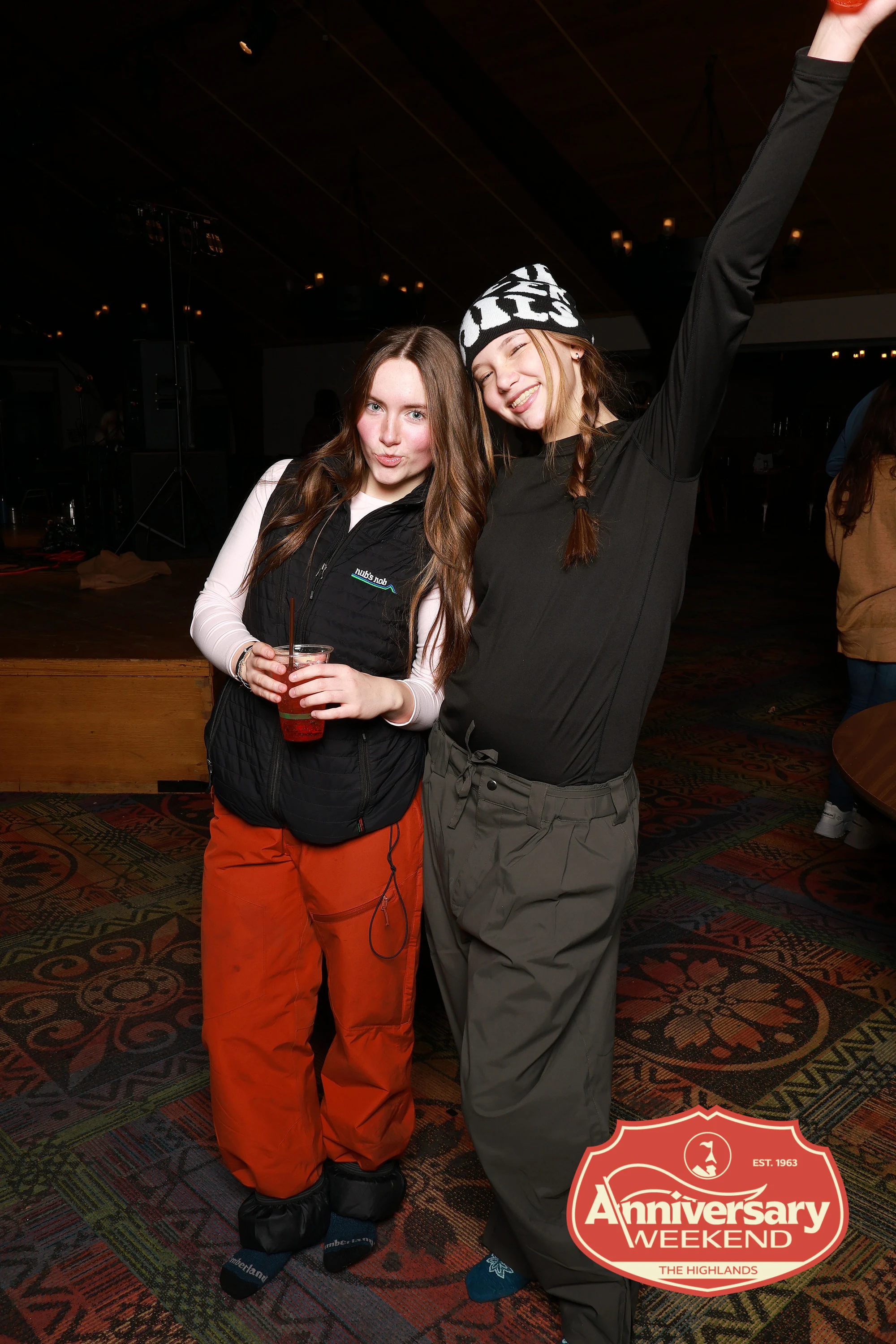 Two friends on the floor at the evening party, one with an arm flung up at The Highlands Anniversary Weekend