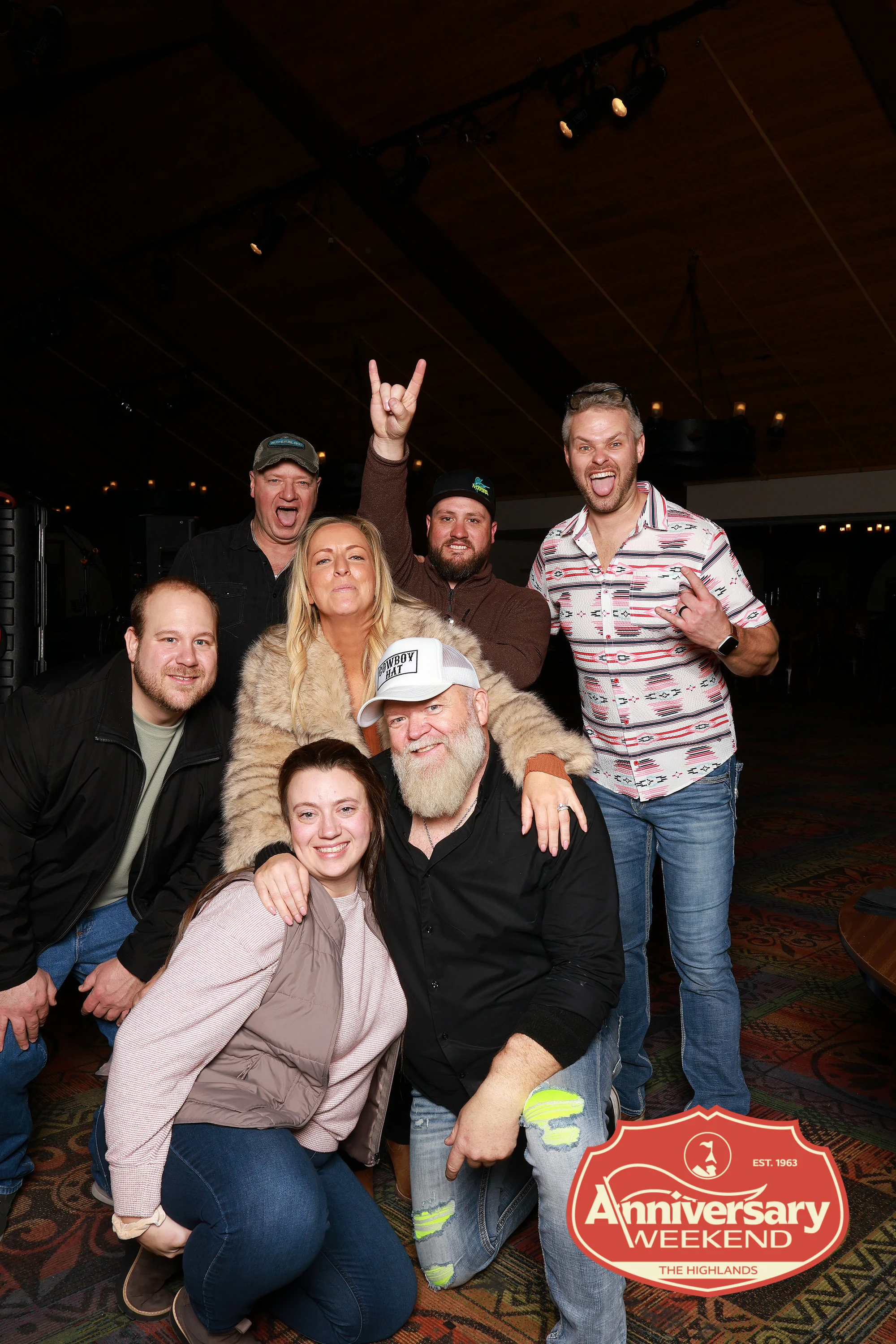 The group at the evening party, one throwing up rock horns at The Highlands Anniversary Weekend