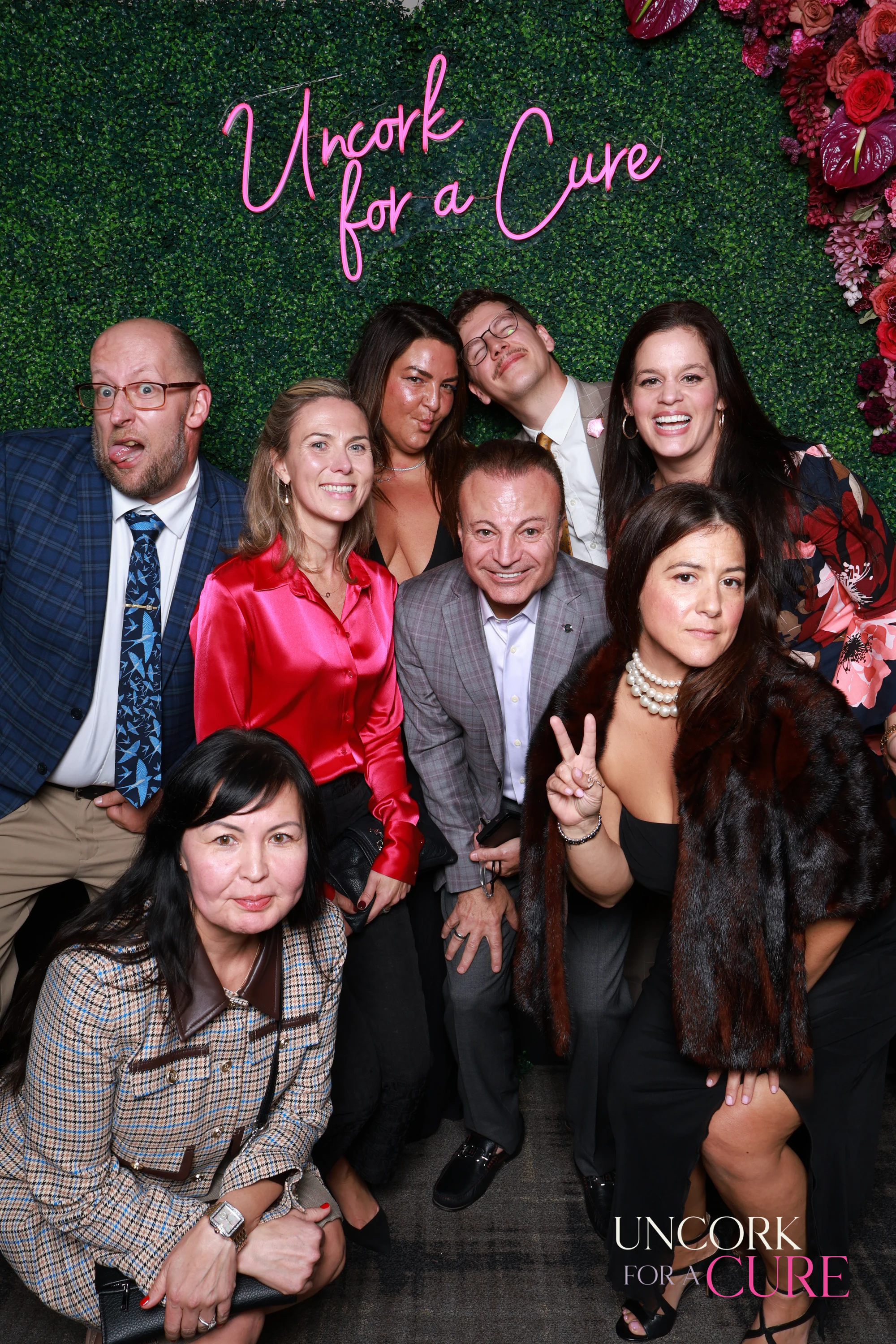 The ten guests again, a peace sign up at the back at Uncork for a Cure 2026