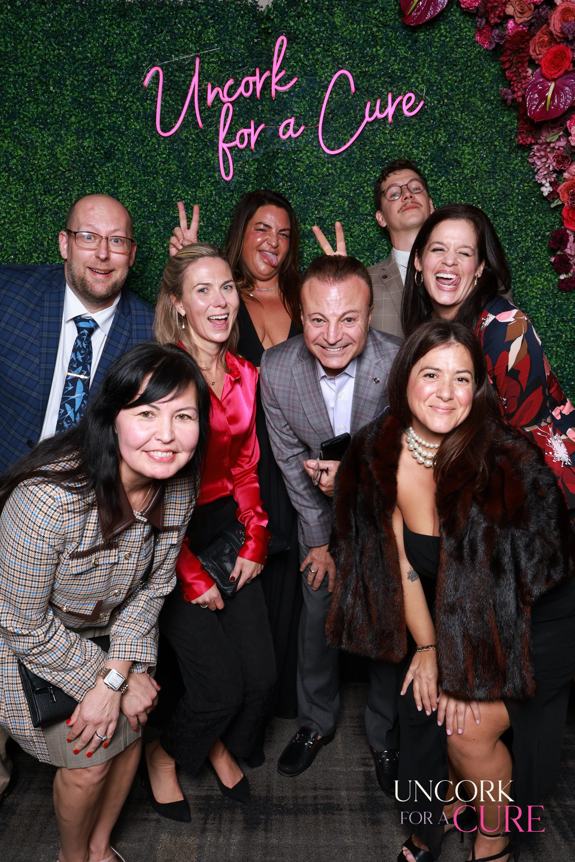 The ten guests leaning in, all smiling at Uncork for a Cure 2026