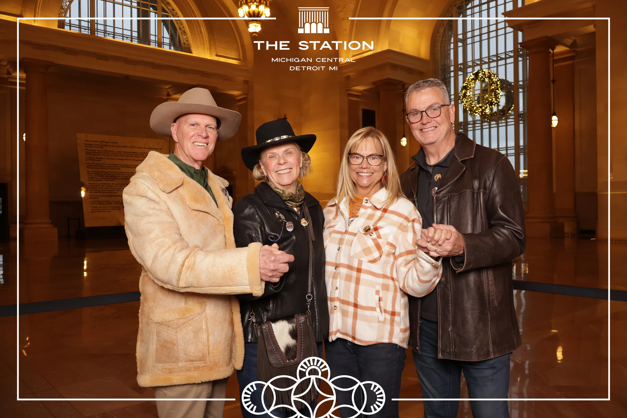 A crew in cowboy hats, mid-hug at Winter at the Station, Michigan Central