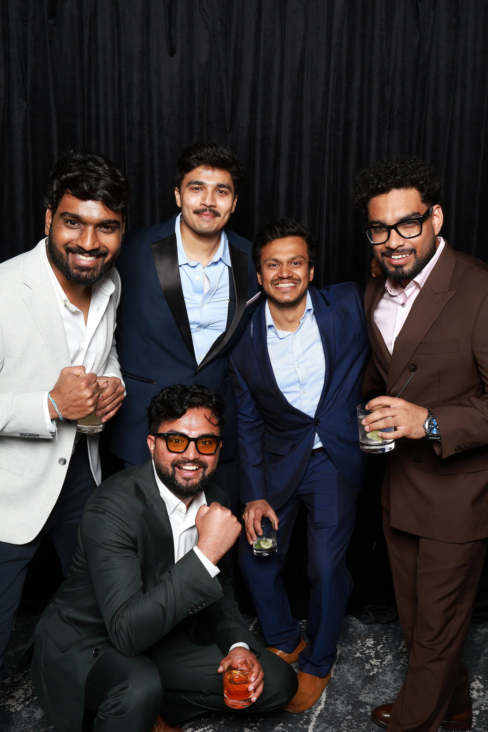 Six friends, one kneeling in sunglasses at Yamini + Hari