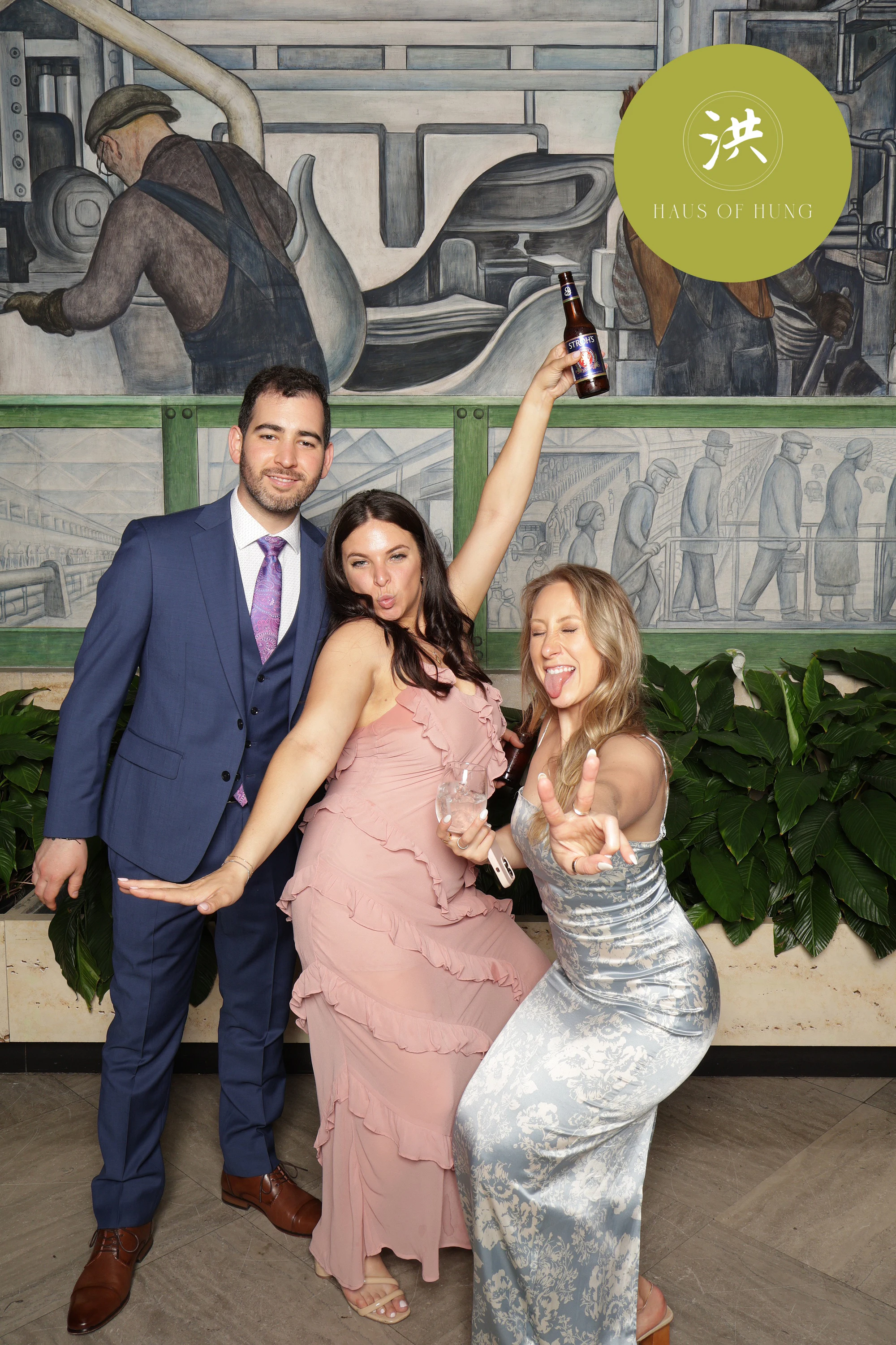 Four in gowns and suits, moving, the mural behind them at Lesley + Kevin at the Detroit Institute of Arts