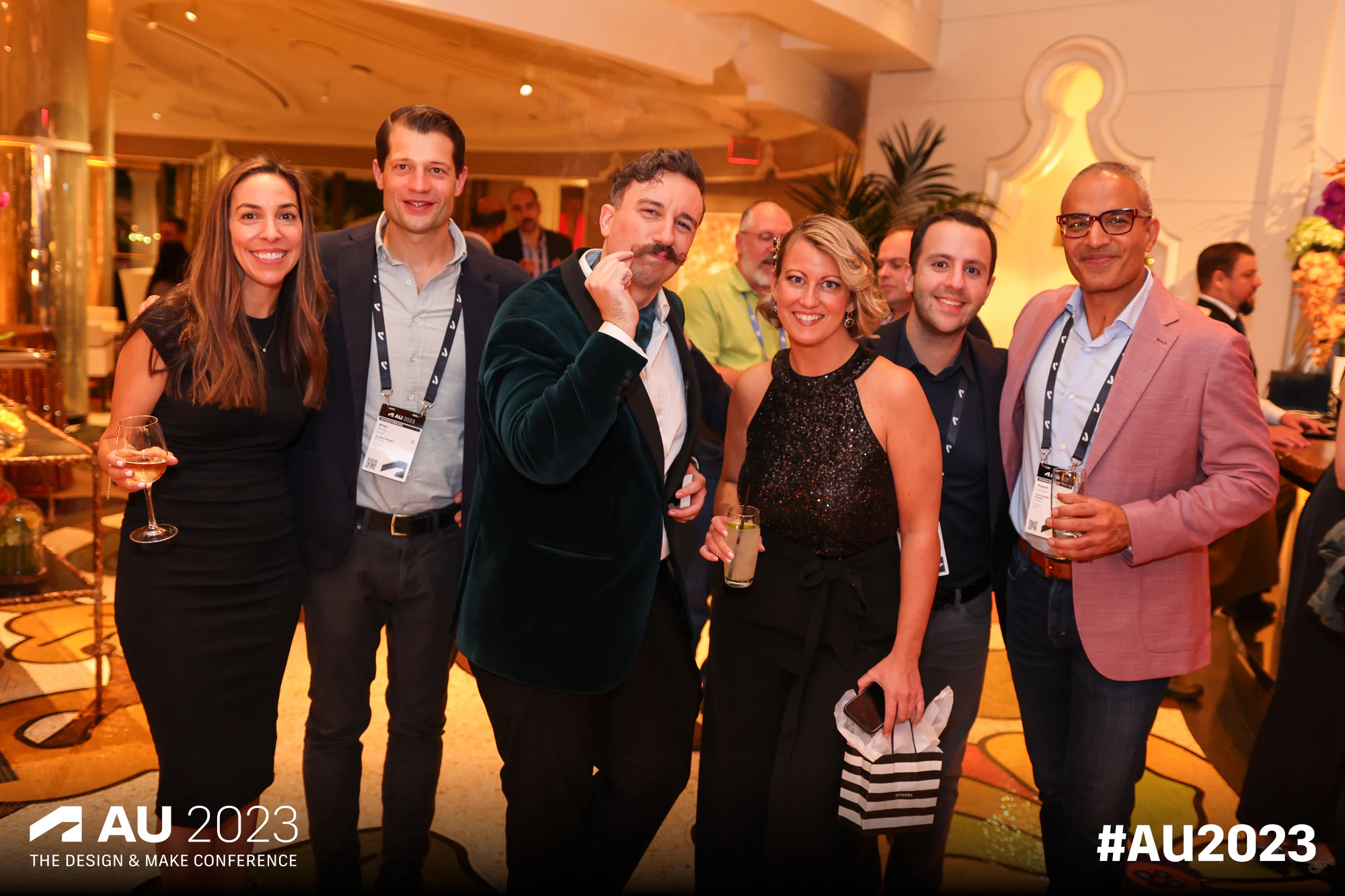 Six mid-laugh in the lush venue at Autodesk University 2023