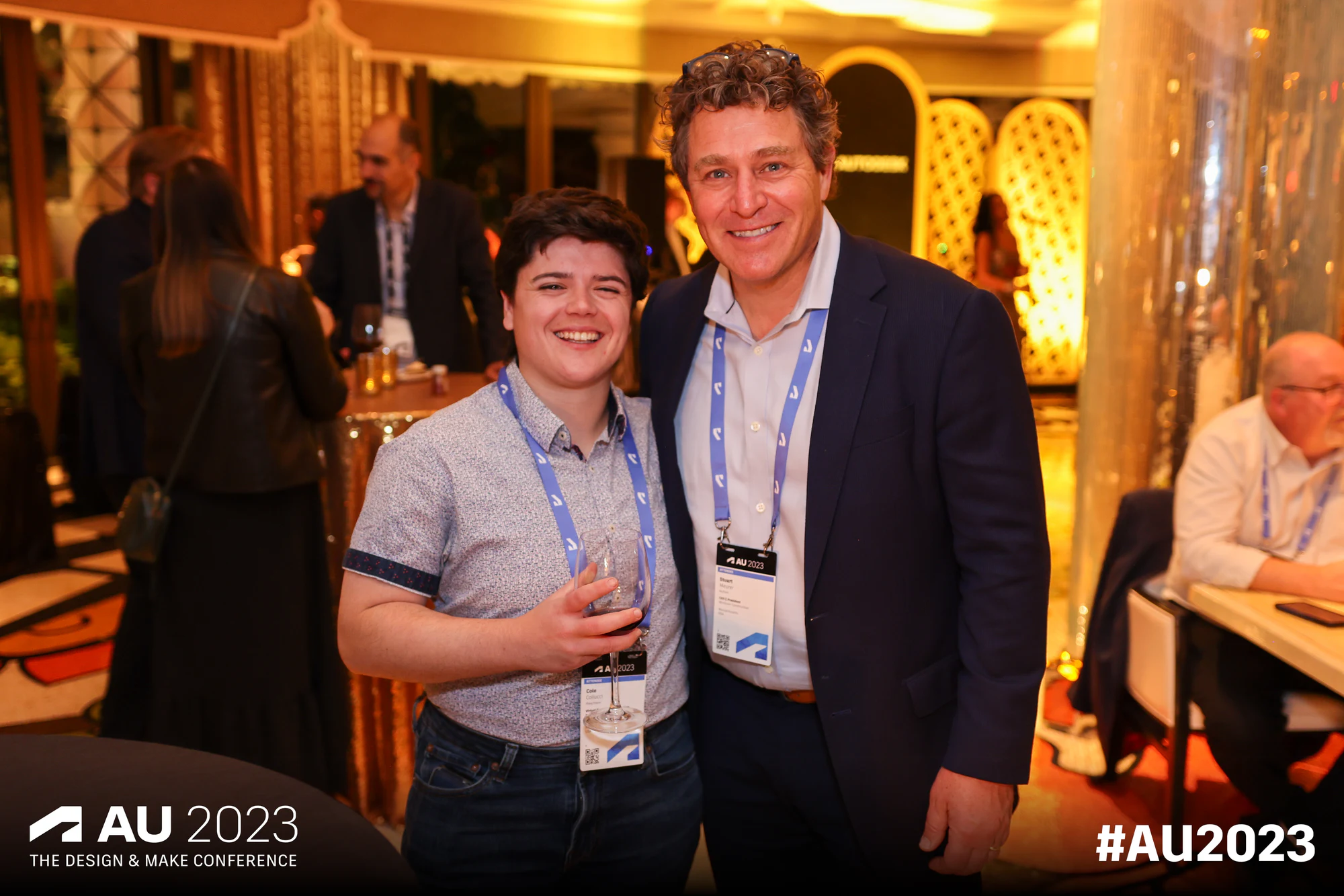 Two in warm venue light at Autodesk University 2023