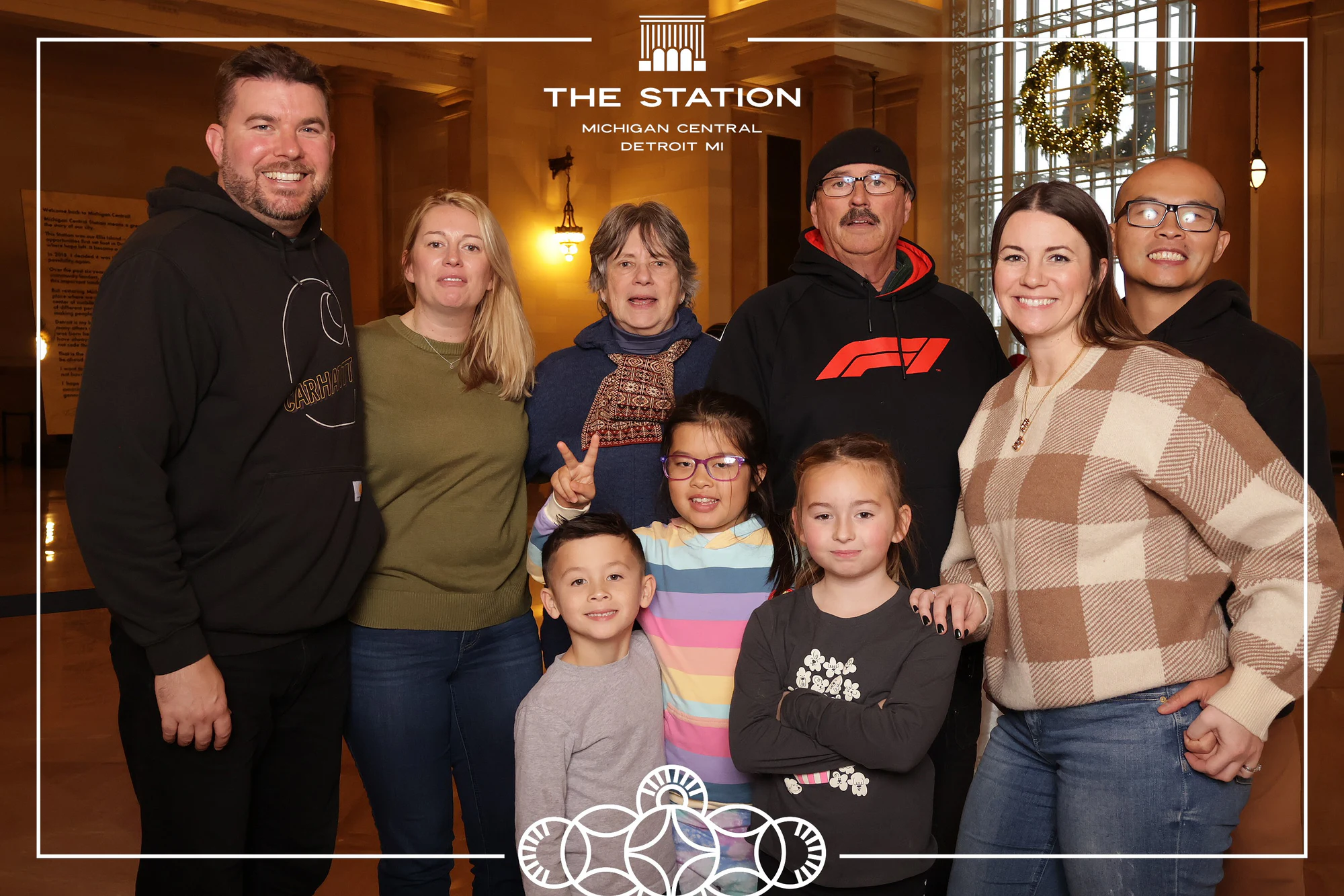 Nine people with the kids up front, the station behind them at Winter at the Station, Michigan Central